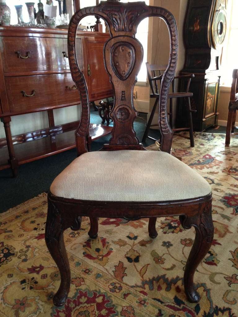 Beautifully carved dark oak side chair with newer upholstery and shell form knees.