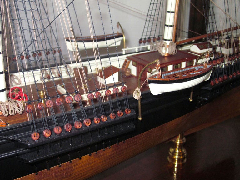 This is a mid 20th century model of the Sovereign of the Seas encased on a beautiful mahogany stand. The decks are individually planked of red mahogany, as are the life boats and there is copper plating on the lower hull and the brass fittings and