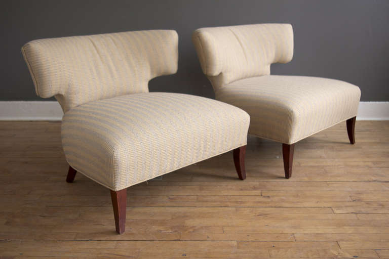 A pair of slipper chairs reminiscent of the designs of William Haines, featuring a T-shaped back and flared feet. Generously sized and quite comfortable. 

A contemporary interpretation of the classic klismos shape.