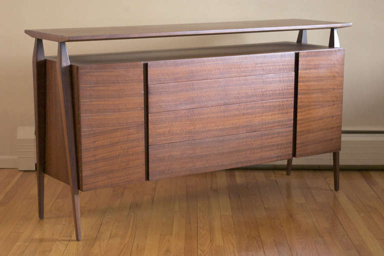 An Italian walnut credenza or sideboard designed by Bertha Schaefer for Singer & Sons, ca. 1954. Features beautifully matched veneer with exceptional color and graining. Cabinet consists of a central bank of four drawers flanked by two doors each