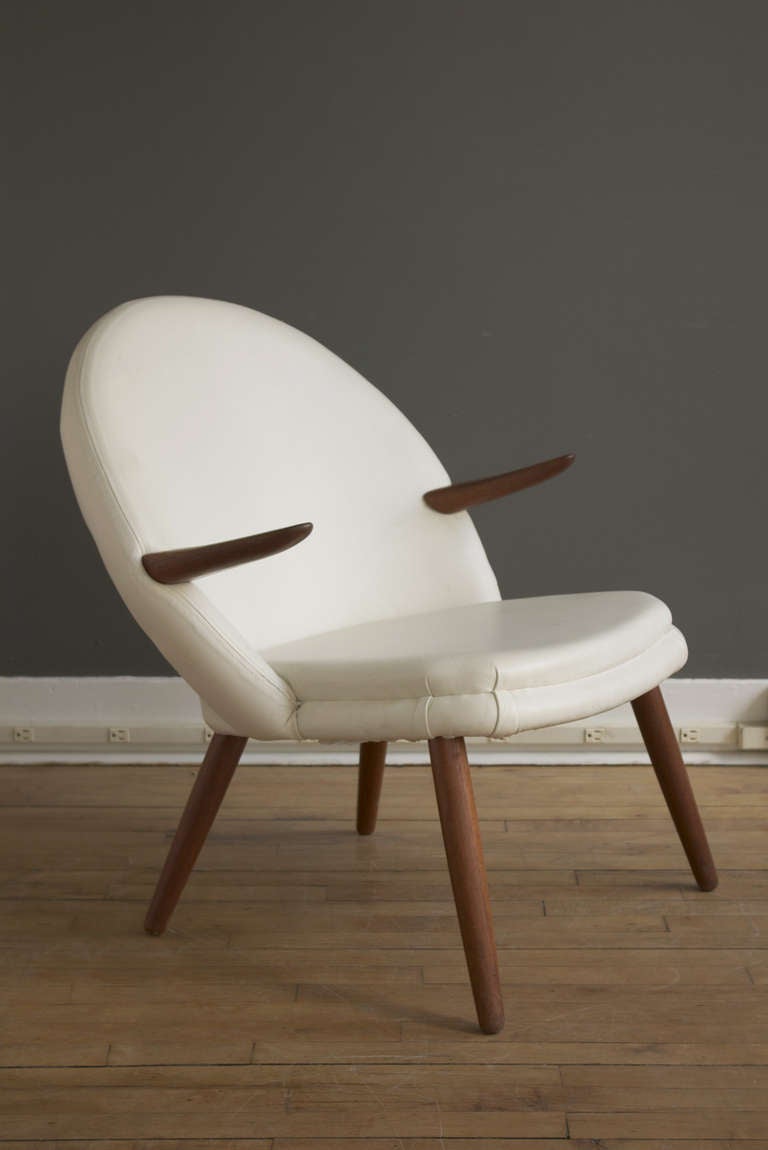 A lounge or easy chair in the manner of Nanna Ditzel by Glostrup Møbelfabrik, ca. 1960. Consists of a circular shell-shaped form with slightly curved teak armrests, supported by four splayed and tapered teak legs.

A comfortable and charming chair