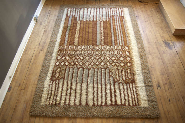 A large and graphic Swedish rya rug reminiscent of the designs of Marianne Richter, ca. 1960. Features an abstract geometric pattern woven in neutral tones of gray, brown and ivory. Long wool pile enhances texture and depth. 

A strong composition