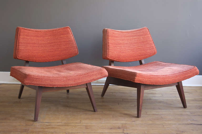 A handsome pair of slipper or low side chairs by Jens Risom, ca. 1950. Each consisting of a curved seat and back supported by a sculptural walnut frame with splayed, tapered feet. Original upholstery is intact but ready for replacement.