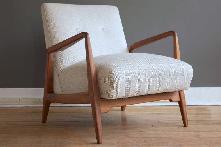 An upholstered lounge chair with a solid walnut frame designed by Jens Risom, ca. 1950.