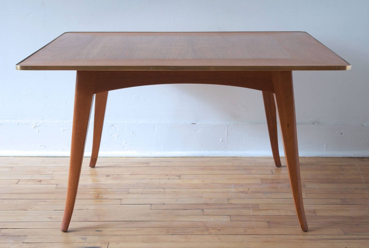 A rare and early square cocktail or coffee table designed by Edward Wormley for Dunbar, circa 1950. 

Handsome splayed leg design with brass trim to top. Retains factory label and Dunbar brand to underside.