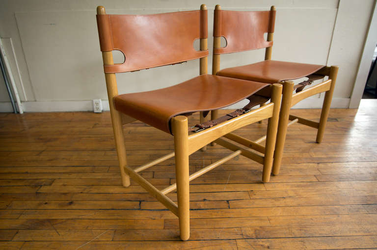 A group of four Børge Mogensen oak and leather dining or side chairs. These were first manufactured in 1964 by Fredericia Stolefabrik, and are currently out of production. There are two Model 3237 chairs without arms, and two Model 3238 chairs with