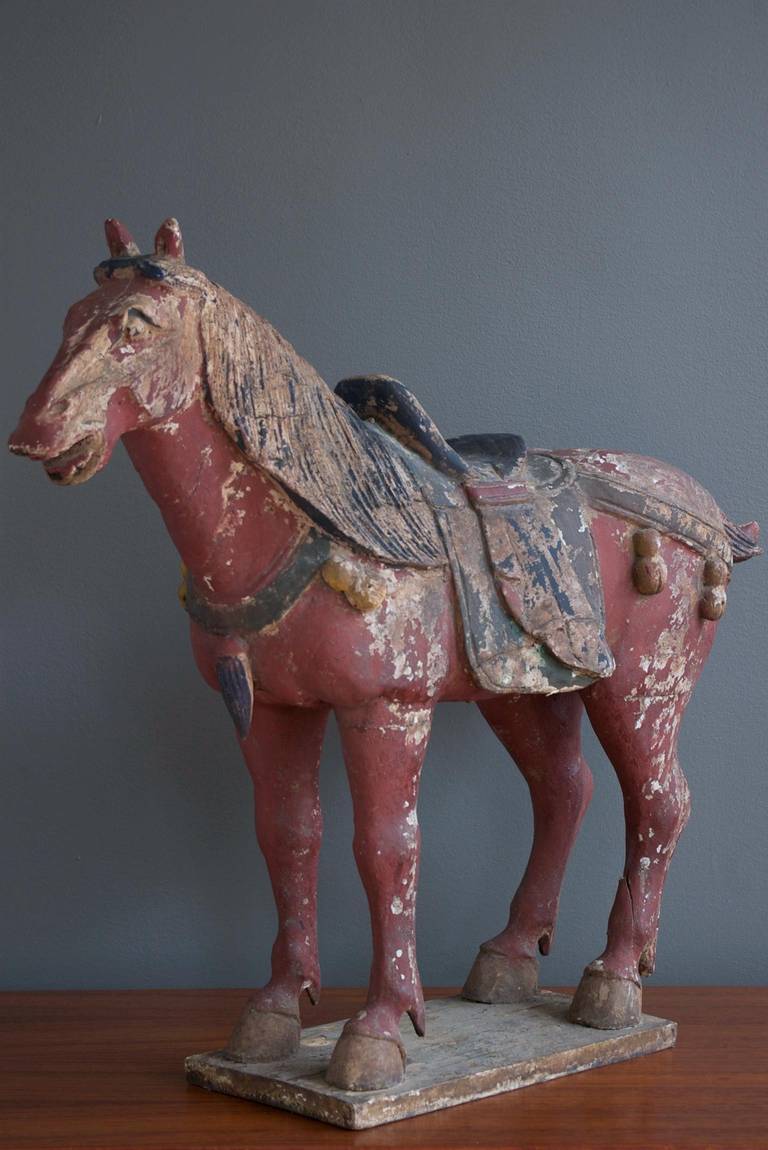 A nicely distressed carved wood Tang style horse, circa 1900.

Base measures 11.5