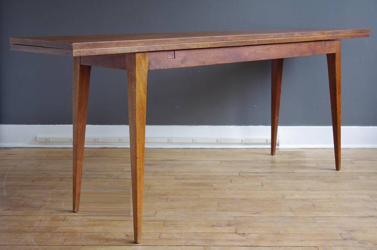 A walnut console table designed by Edward Wormley for Dunbar, ca. 1950. 

Flip-top enables the piece to also function as a dining or work table.