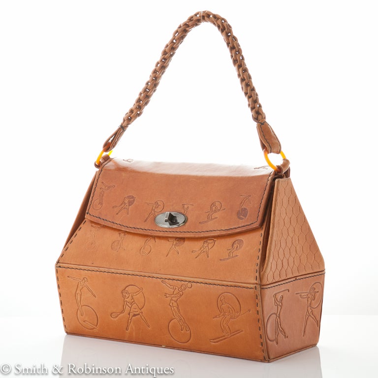 A beautiful quality leather handbag depicting on pressed leather a collection of sporting activities, Italy c.1955-60
It has a platted leather handle and a silk interior.
& a handle drop of 6″
