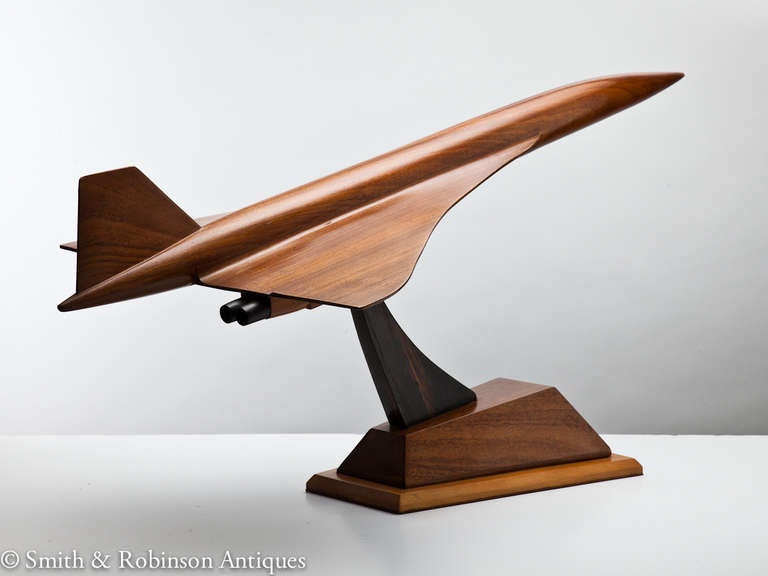 Concorde, iconic in shape and ahead of its time. This sleek elongated model of Concorde exhibits a beautifully crafted fuselage in fruit wood, circa 1975-1980.
The Olympus engines and arm of the stand are in coromandel. Looks great from every