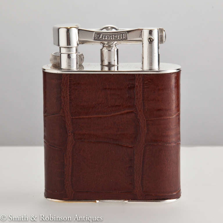 A superb quality Dunhill table lighter c.1940 
The body has been finished in alligator leather.
It is in perfect working condition, the arm & top have been re-silverplated in recent years.
All patent marks are shown & it is in full working