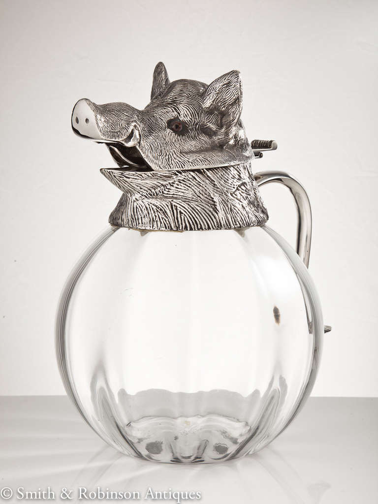 A very large and impressive boar's head pitcher with hinged lid on a glass base date Spanish, circa 1960-1965.

A superb quality piece realized in highly detailed silver plate and a thick glass body, all of which embodies a very substantial and