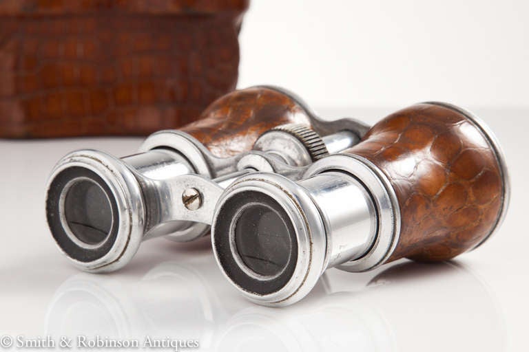 A great pair of vintage binoculars in their original case c.1910

The perfect vintage opera & jockey club accessory.

The beautiful quality vintage crocodile skin is also used on the barrels & the optic lenses are all in good condition.

We