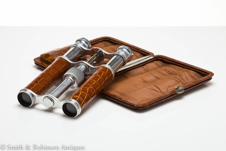A most elegant case containing a miniature pair of field glasses in unused condition, with a extended length of 7 1/2