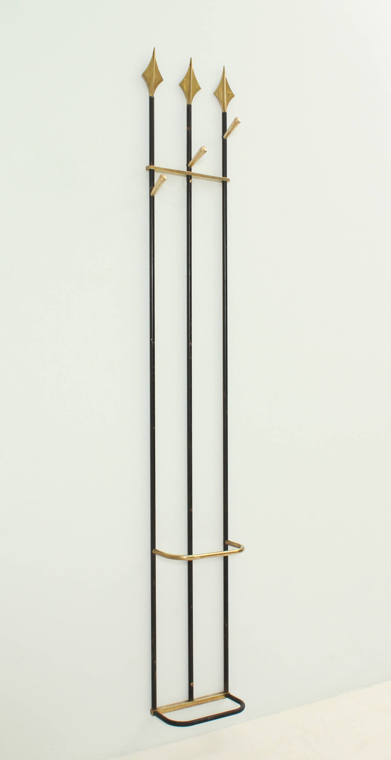 Amazing coat rack in the style of a gate, France 1950's. Brass and black lacquered metal. Three hangers and umbrella stand.