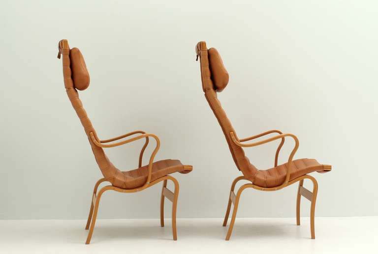 A pair of high back Eva chairs designed by Bruno Mathsson in 1941 for Dux, Sweden. Bent beechwood, leather and canvas cover.