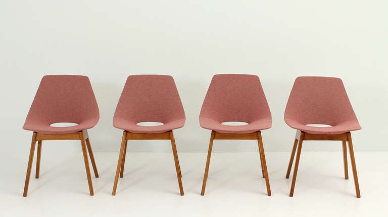A set of four Tonneau chairs designed by Pierre Guariche in 1954 for Steiner, France. Rare version with upholstered seat and wooden bases. New upholstery and restored oak wood bases.