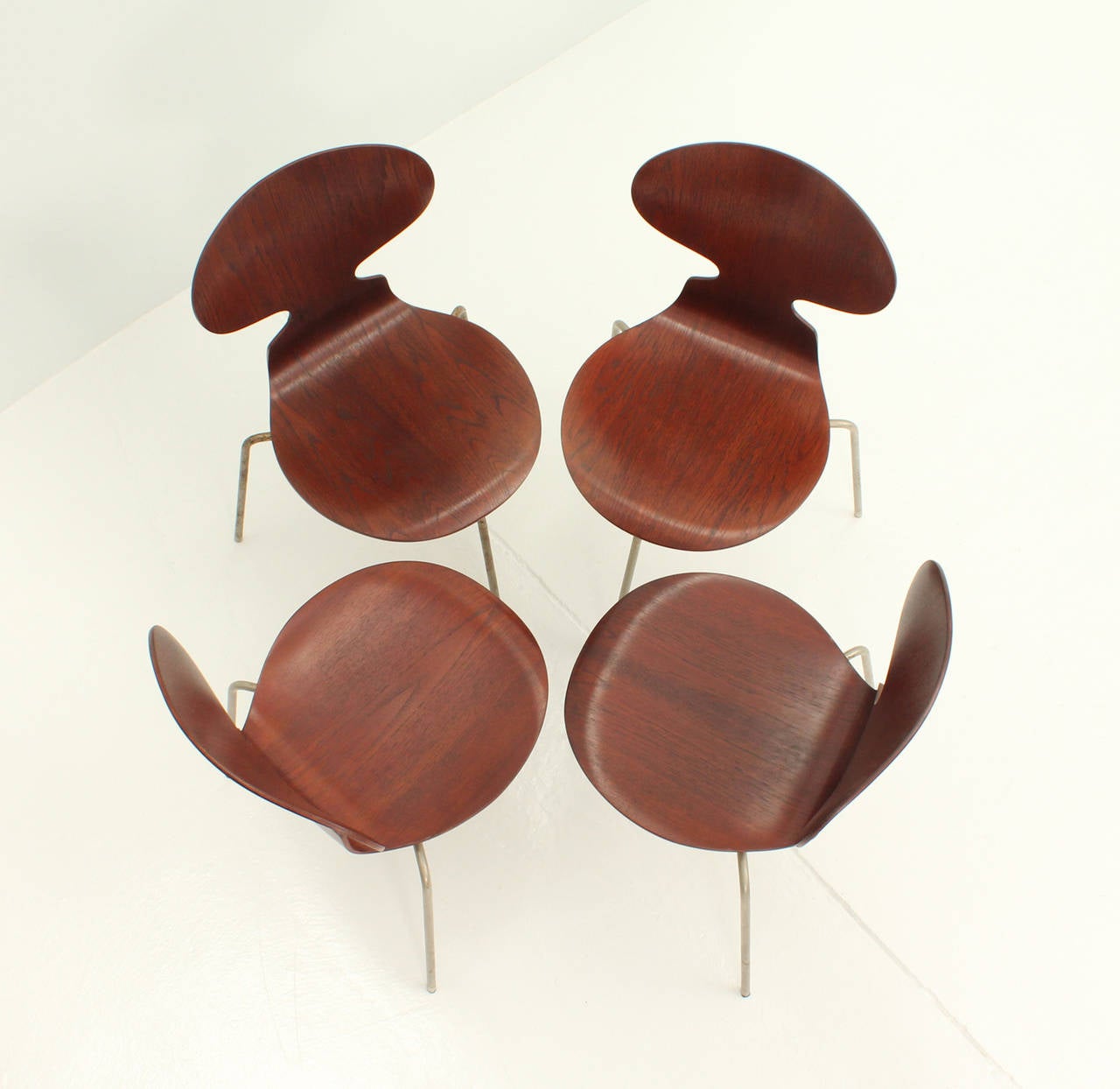 A set of four Ant chairs designed by Arne Jacobsen in 1951 for Fritz Hansen, Denmark. Early edition in teak wood and steel, three legged.