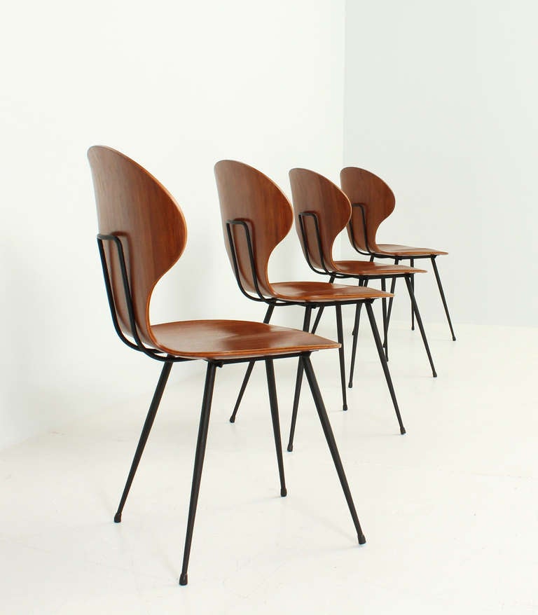 A set of four chairs designed and produced by Carlo Ratti, Italy, 1950's. Plywood seat and black metal base. Signed.