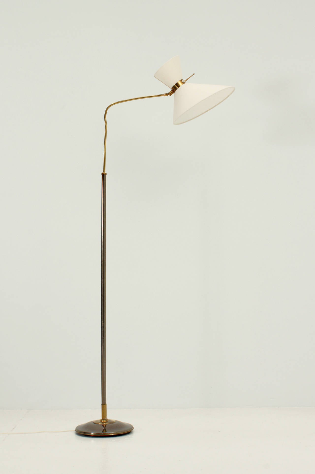 Floor lamp by Lunel, France 1950s. Brass and bronze base with adjustable height arm and rotary double shade with new fabric.