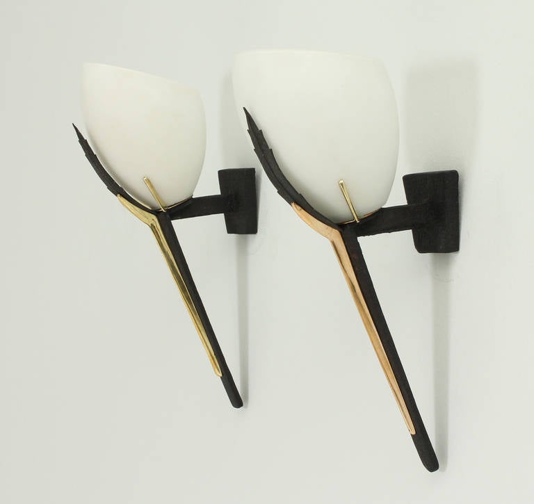 A pair of french torch sconces from 1950's. Back lacquered metal, brass details and mate opaline glass.