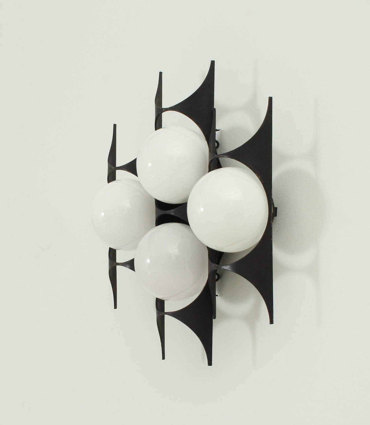 Spanish brutalist sconce from 1960's. Black enamelled iron structure with four opal glass globes.