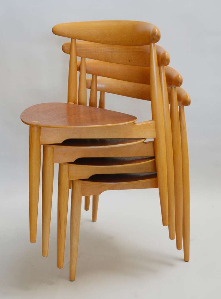 Four stacking chairs designed by Hans Wegner for Fritz Hansen. These have a beech frame and teak plywood seat. These have an older refinish.