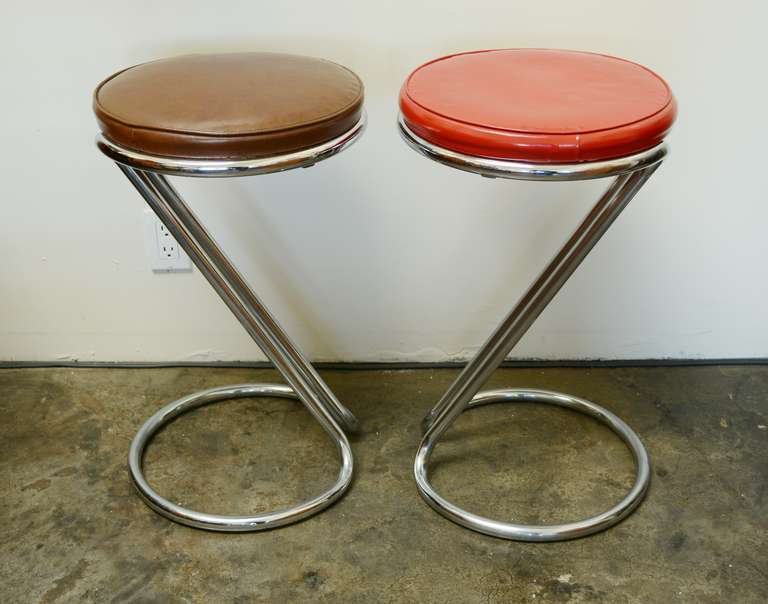 Pair of Z stools designed by Gilbert Rohde for Troy Sunshade. These are in original condition with the original upholstery. There is a small cut in the brown vinyl.