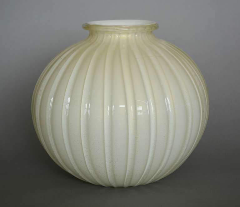 This vase has a white base with a crackled gold layer and then clear glass with thick clear ribs.