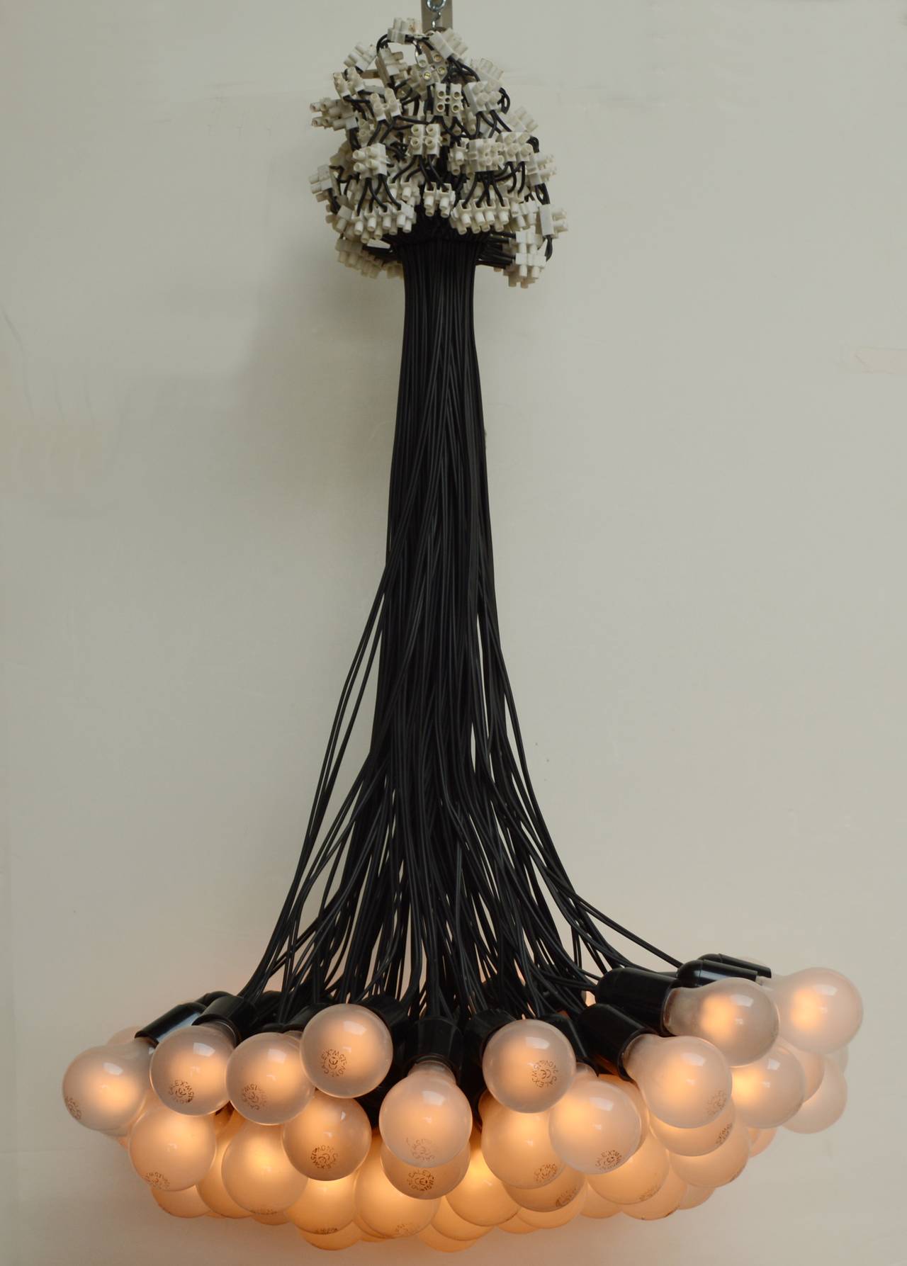 Designed by Rody Graumans in 1993 this chandelier uses only what is necessary to create light, bulbs, wire and connectors. Missing one bulb at the time of listing.