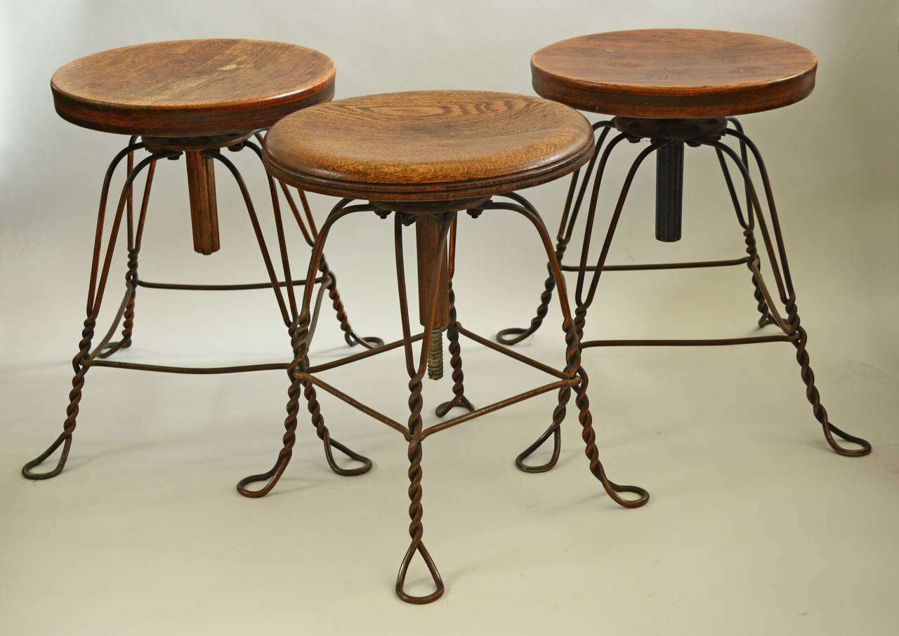 Turn of the 20th century twisted steel wire stools. These are adjustable and raise to a height of 24