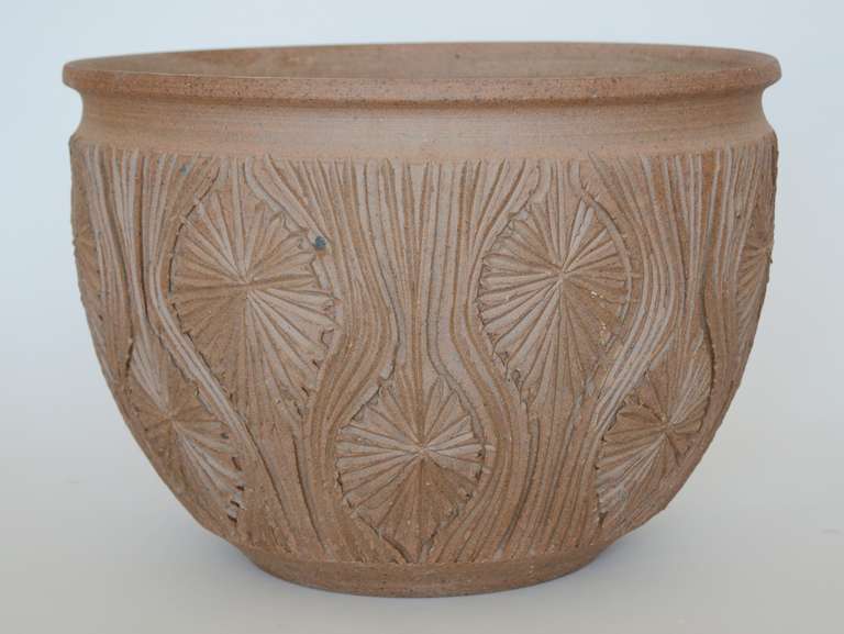 Stoneware planter designed by David Cressey and Robert Maxwell for Earthgender. This planter features a design of incised lines and starbursts. The outside is not glazed. The lower three quarters of the inside is glazed. This planter is not drilled.