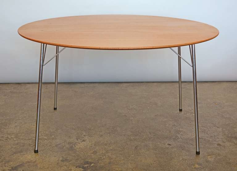 Fritz Hansen dining table designed by Arne Jacobsen. This table was designed to go with Jacobsen's Ant chairs. The table has a teak top with chrome legs.