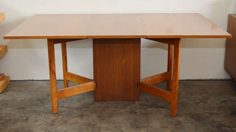 Drop leaf dining table designed by George Nelson. This table features a unique hinge design. The table can be used fully open, half open or as a console table closed. This table is in original condition. It has the patina expected with a table this