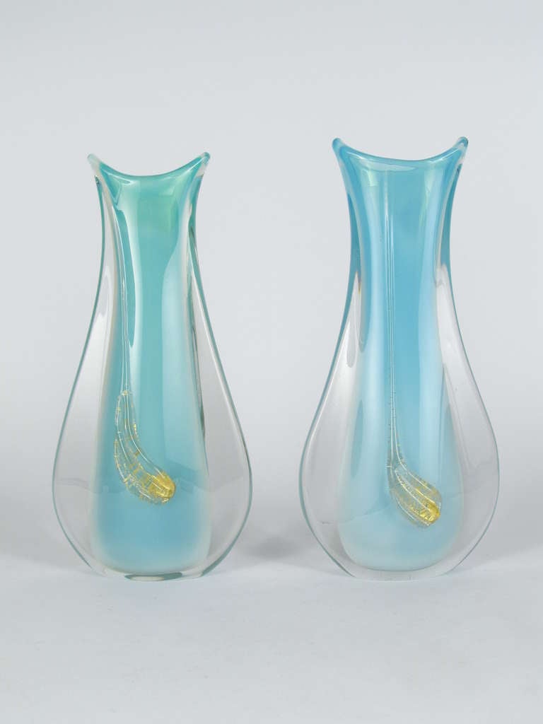 This is a beautiful and graceful pair of unsigned Murano Sommerso glass vases, each one with a very sinewous swoosh of gold applied to both the front and back. Each one is unusual and appealing. But as a pair they are quite rare. Possible