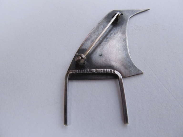 A charming and simple abstraction of a standing bird, by American master jeweler Betty Cooke.