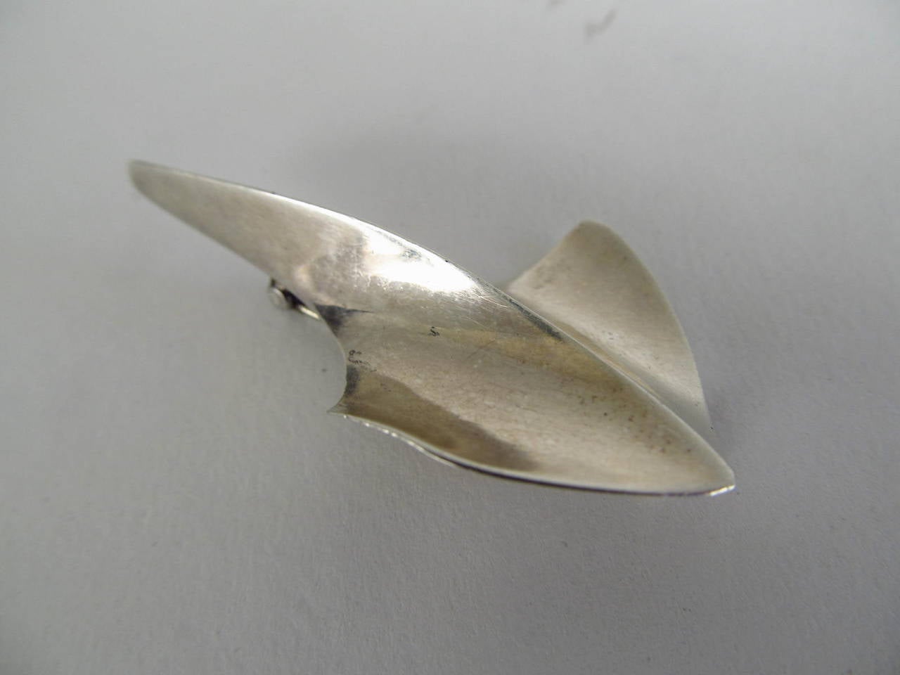 A very fluid organic form by American modernist jeweler Russell Secrest. Marked Secrest Sterling.