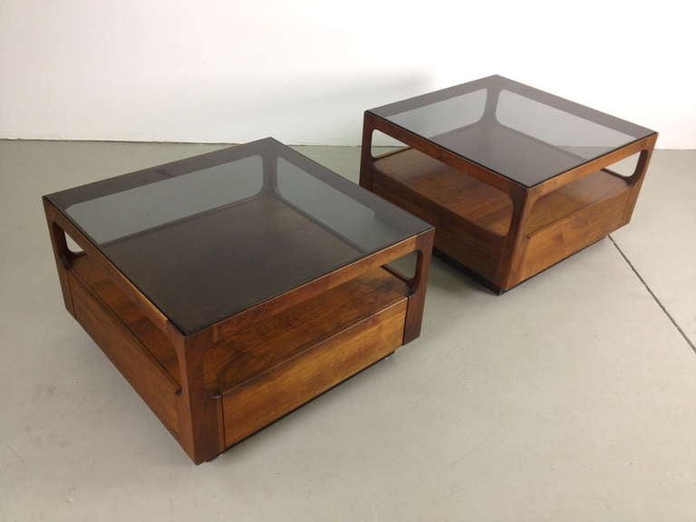 Pair of Brown Saltman Walnut and Smoked Glass End Tables with Drawers by John Keal.  Minor scratches to glass tops.   Small filled ding on one table as pictured.