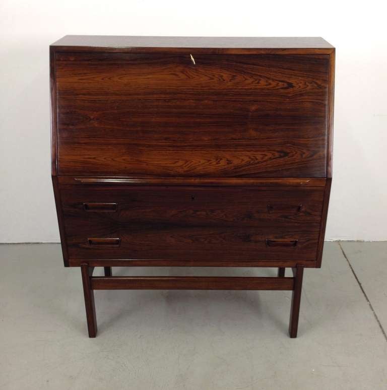Beautiful Danish Modern Rosewood Secretary Desk Cabinet.  Features a spacious fold down secretary desk on top with 2 drawers below for additional concealed storage.  Very minor repair to the interior and minor veneer bubbling to inside back wall as