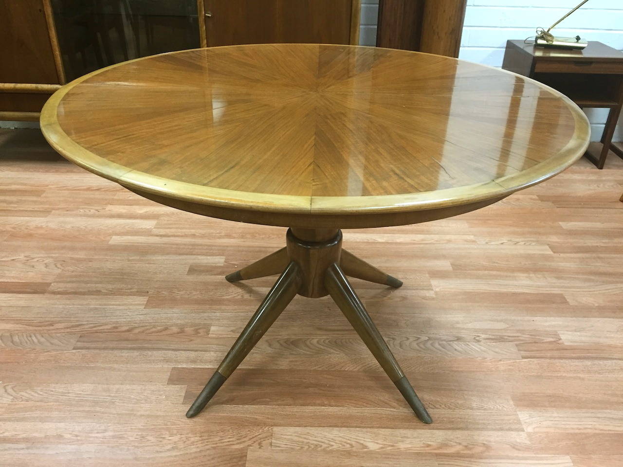 Sculptural dining table with three leaves by Melchiorre Bega. Sold in as found condition for restoration. Lacquer finish has cracking from age. Minor chips as well as a minor repair to base which is not very notable. Leaves each measure 18