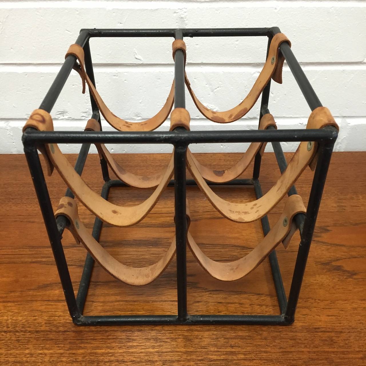 Vintage iron and leather four bottle wine rack by Arthur Umanoff. Good original condition with an ape appropriate patina to the leather as pictured.