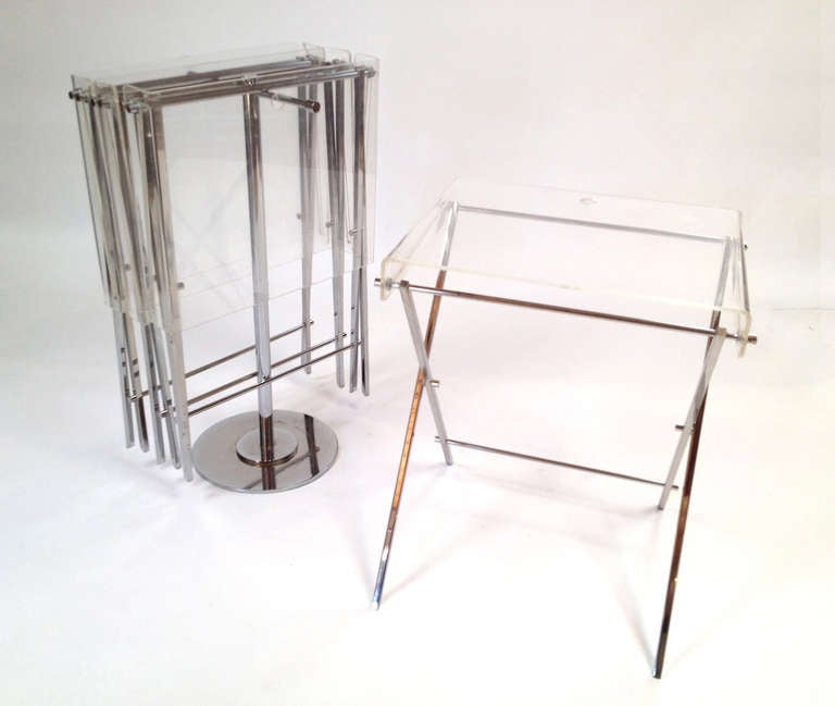Set of 4 Charles Hollis Jones Chrome and Lucite Folding Tray Serving Tables. Tables hang on the stand when not in use. Good original condition with a natural patina to the chrome and some expected surface wear to the lucite surfaces from use (1