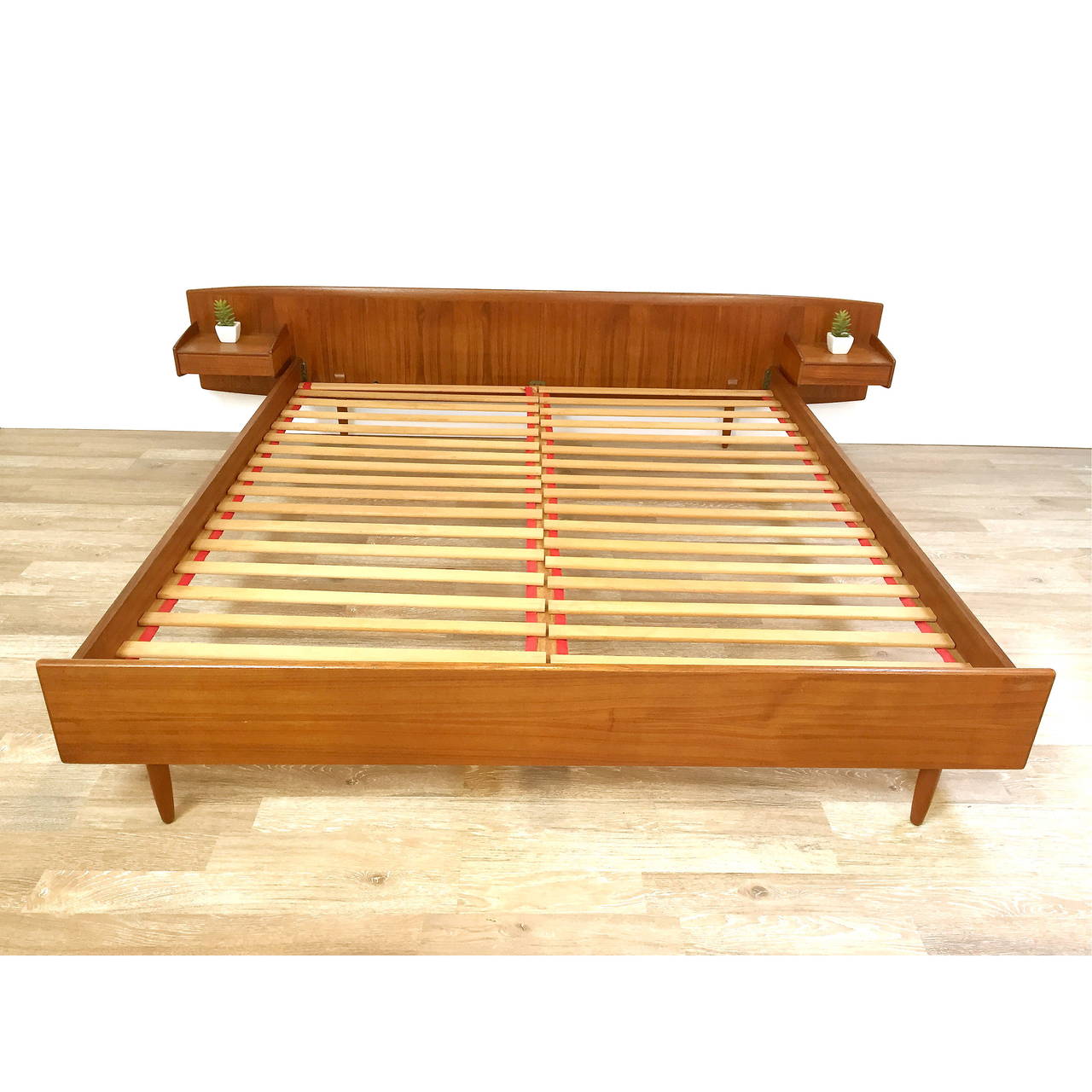 Danish modern teak California king platform bed with floating nightstands. Very nice original condition. Minor scratch and mark near right nightstand (picture eight). Marked with Danish Furniture Control Tags as shown.