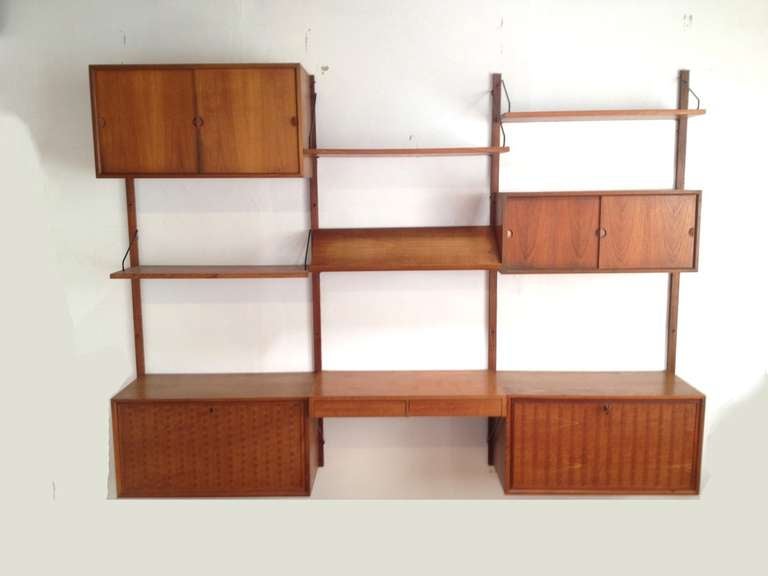 3 Section Danish Modern Cado Wall Unit by Poul Cadovious. This unit is completely modular and includes (2) Basket Weave front cabinets w/ original keys, a writing desk surface w/ 2 drawers, an angled reading/display shelf, 2 Storage cabinets with