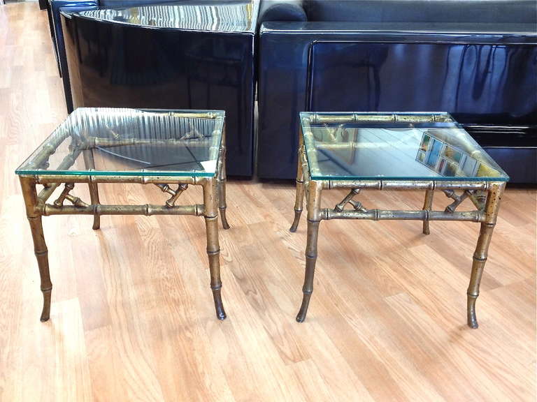 Pair of solid cast aluminum faux bamboo klismos lamp end tables.  Good original condition with some minor wear to the gilt finish from age.  Glass tops have some minor wear and should be replaced.