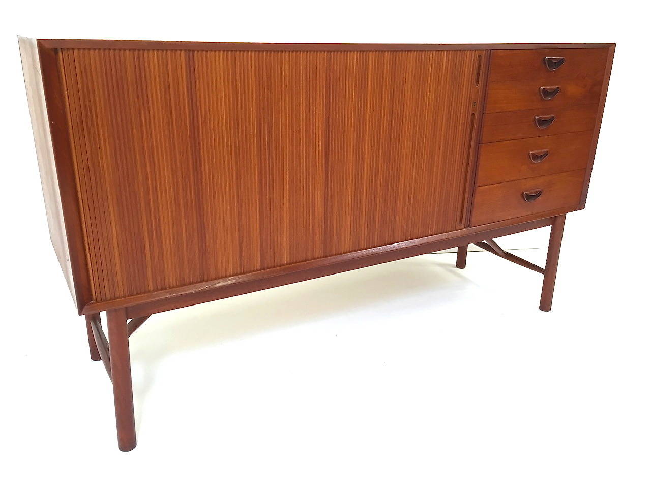 Danish modern teak tambour door credenza by Peter Hvidt & Orla Mølgaard Nielsen. Features a spacious storage area behind the tambour doors with two adjustable shelves as well as five drawers on the right hand side. Top quality Danish design and
