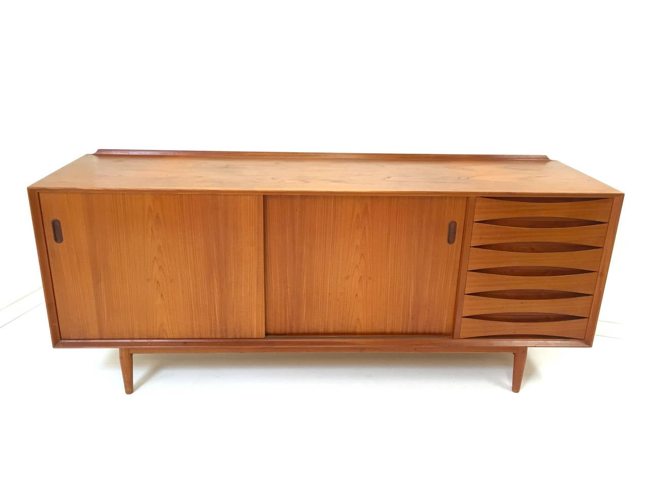 Danish modern teak credenza with reversible doors by Arne Vodder for Sibast. Iconic Danish design with reversible teak/black lacquer doors and signature Vodder bowtie drawers. Top quality Danish Design and construction in excellent refinished
