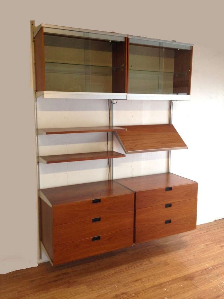 George Nelson 2 Section Wall Mount CSS Wall Unit for Herman Miller.  Completely modular unit features 2 3 drawer chests (note continuous wood grain on cabinet faces) 2 Glass front display cabinets with built in lights, Angled magazine display shelf,