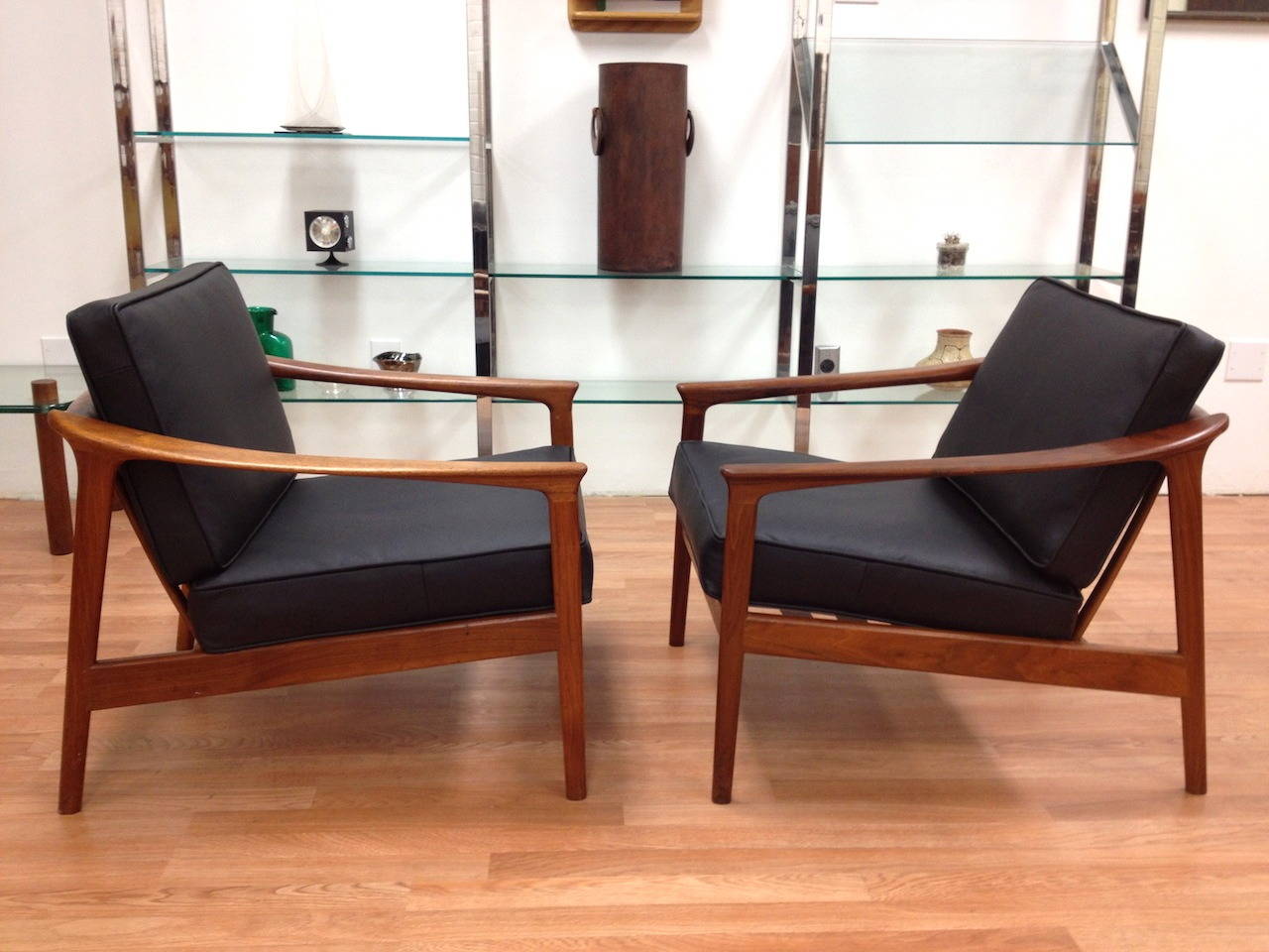 Pair of DUX Danish modern walnut and black leather lounge chairs by Folke Ohlsson. Beautiful walnut frames with brand new straps and quality black leather upholstery. Marked with DUX labels as shown.