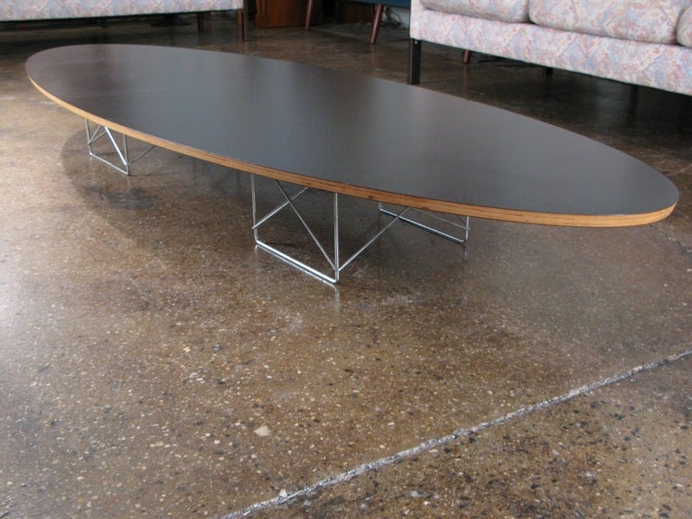 Long, low surfboard coffee table by Charles Eames designed for Herman Miller. Table is over seven feet long! Originally designed in the 1950's, this table was reissued in the early 1990's.

Dimensions: 90
